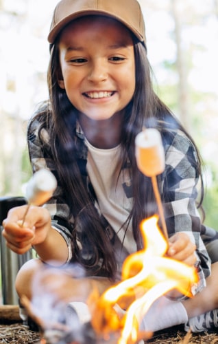 Girl roasting marshmallows at summer camp