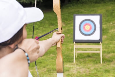 Girl doing archery at summer camp.
